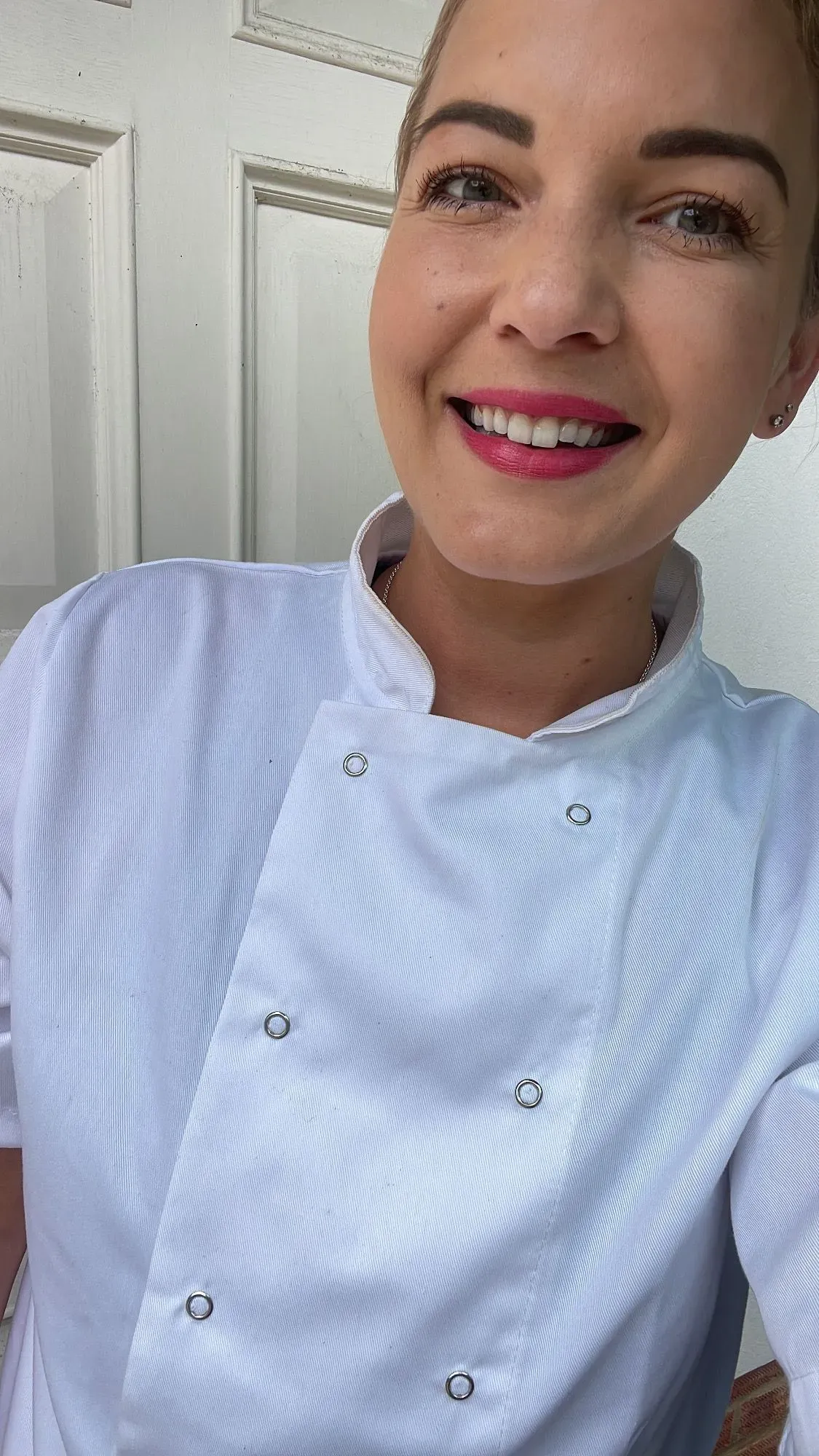Startup founder Bianca smiling in a casual white shirt in her home kitchen